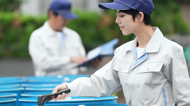 ハンディターミナルで荷物をスキャンする女性作業員