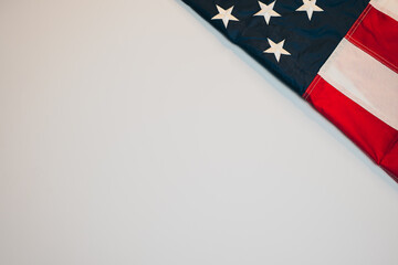 American flag flat lay. American flag draped against a plain background showcasing vibrant colors and detailed star and stripe patterns