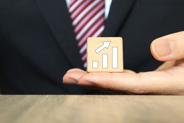 スーツの男性と右肩上がりのグラフ