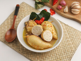 Squid with tofu filling cooked in curry sauce in white bowl