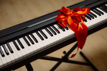 A digital piano with a red ribbon tied around it, suggesting it is a gift.