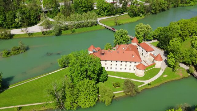 Otočec, Slovenia, a castle on the river, aerial footage, drone video a green river and castle on the island