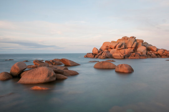 France,Bretagne.Pink granite rock formations at the coast  on a sunny summer evening