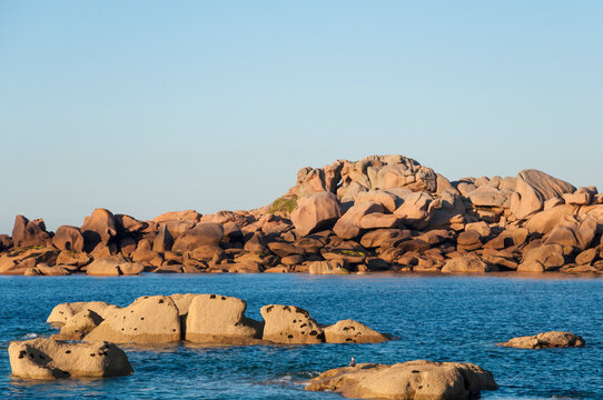 France,Bretagne.Pink granite rock formations at the coast  on a sunny summer evening