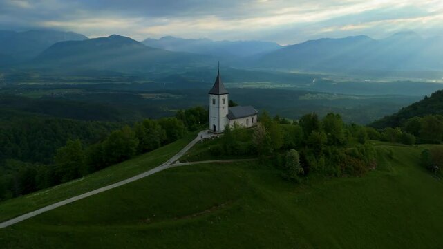 Amazing light rays above the church on the hill in Jamnik, Slovenia, saint Primus and Felician, drone video, aerial footage