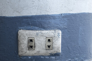 Old electrical power socket plug outlet on concrete wall.