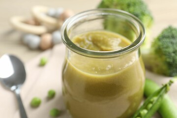 Baby food. Tasty puree in glass jar and ingredients on table, closeup