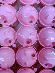 collection pink containers resembling playful animal designs is arranged neatly in store. they are filled with colorful candies, showcasing an inviting treat selection for customers. close up.