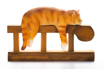 A charming ginger cat figurine, peacefully sleeping draped over a rustic wooden stand. Isolated on white, perfect for themes of relaxation, comfort, and home decor.