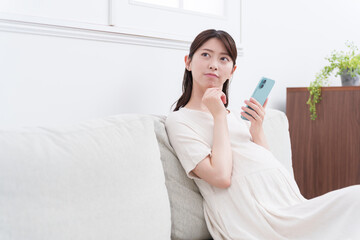 スマホを使う妊婦（悩む・考える）