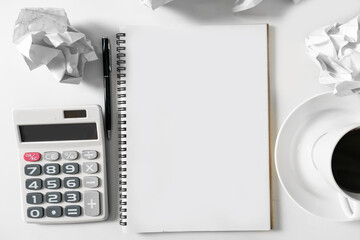 Blank white notebook with crumpled paper on white table with calculator and coffee cup ,for mockup white notebook to put text graphic design