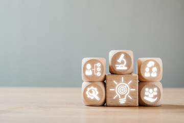 Wooden blocks with icons symbolize problem solving, innovation, and teamwork in a business context.