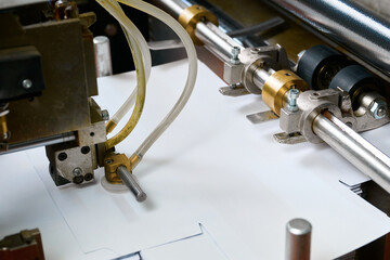 Innovative paper sheet feeding mechanism enabling efficient glue application in modern machinery
