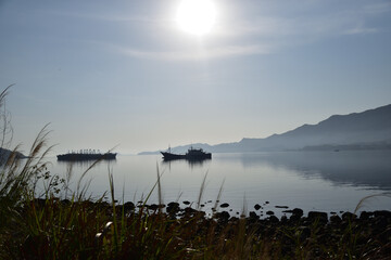 Still Waters and Distant Ships under Morning Sun