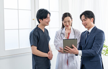 立ちながら話すビジネスマンと医療従事者