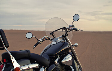 A motorcycle stands still beneath a vibrant sunset, symbolizing freedom, adventure, and the thrill of exploring new roads ahead.