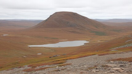 Autumnal landscape featuring a serene mountain lake nestled beneath a majestic peak