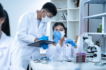 In the laboratory, several researchers conduct blood tests and analysis on samples, using science...
