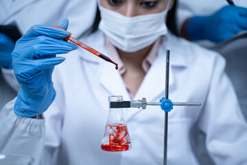 Laboratory research with blood sample in tube being dripped for medical test using liquid medicine...
