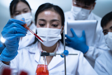 In the laboratory, blood is carefully dripped into test tubes for medical and biology research,...
