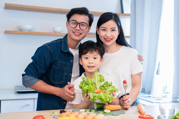 Naklejka premium Family health and wellness: a mother father and son pose with fresh produce in their kitchen