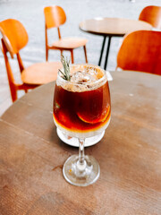 Refreshing cold coffee with lime and ice cubes on a wooden table at a cafe