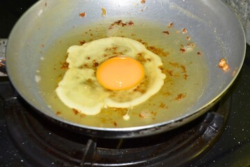 Frying egg, sunny upside on a pan
