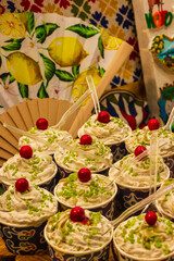Assorted Cups of Dessert Topped with Cherries and Green Sprinkles