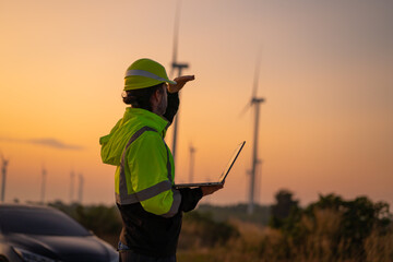 Engineer wearing uniform inspection and survey work in wind turbine farms rotation to generate...