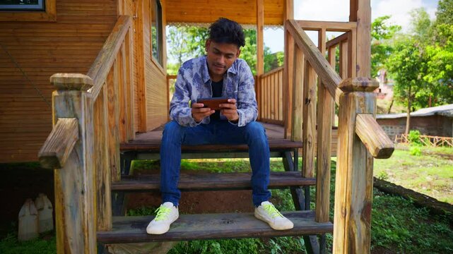 Vacationer guy enjoys game outside on wooden stairway