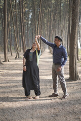 Fototapeta premium A romantic Indian couple embracing lovingly with closed eyes in a serene pine forest
