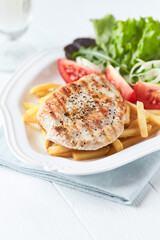 Grilled Turkey Breast with fresh salad. Bright background.	
