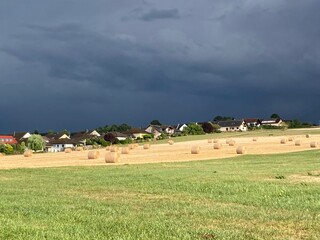 Dark ominous clouds in front of the hurricane over a green field. Awesome photo of the texture of storm clouds. Adverse weather conditions. Wallpaper force of nature. Discover the beauty of earth.