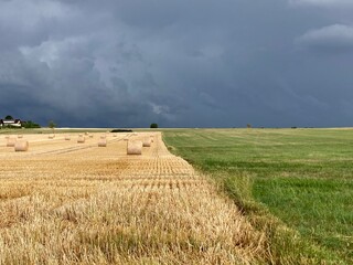 Dark ominous clouds in front of the hurricane over a green field. Awesome photo of the texture of storm clouds. Adverse weather conditions. Wallpaper force of nature. Discover the beauty of earth.