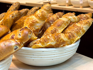 Assorted fresh baked bread in basket display with croissants and rolls