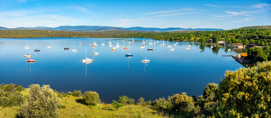 Lake between the mountains with many small sailing boats to enjoy free time, Atazar, Madrid.