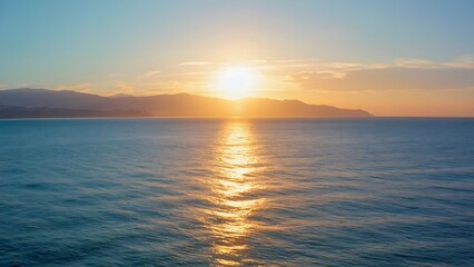 Obraz premium Sunset over ocean with mountain silhouette