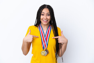 Teenager girl with braids and medals over isolated pink background with surprise facial expression