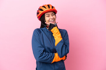 Teenager cyclist girl isolated on pink background happy and smiling