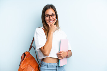 Young student woman isolated on blue background happy and smiling