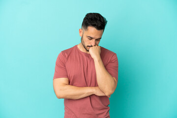 Young caucasian man isolated on blue background having doubts