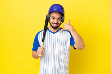Young caucasian man playing baseball isolated on yellow background making phone gesture. Call me back sign