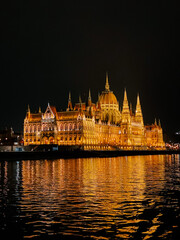 Fototapeta premium Hungarian Parliament Building illuminated at night along the Danube River in Budapest