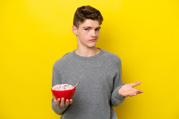 Teenager Russian woman holding a yellow background making doubts gesture while lifting the shoulders