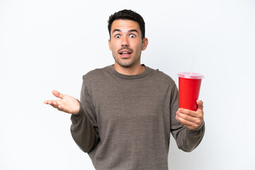 Young handsome man holding soda over isolated white background with shocked facial expression