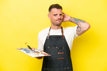 Young artist caucasian man holding a palette isolated on yellow background having doubts