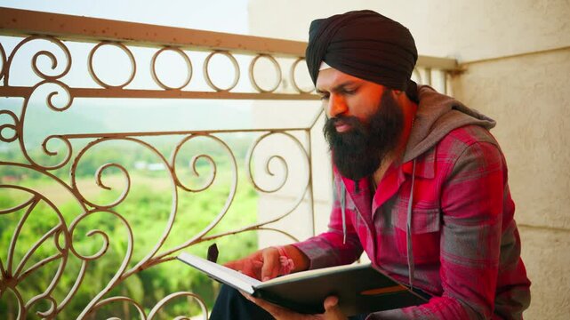 Turbaned reader focuses deeply near leafy veranda