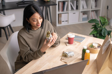 Asian woman eating healthy meal while working, Businesswoman having a lunch break at the office