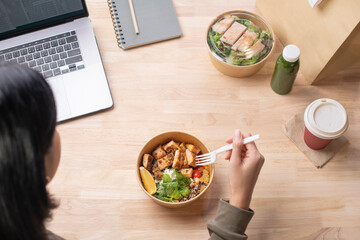 Asian woman eating healthy meal while working, Businesswoman having a lunch break at the office