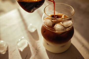Chilled espresso poured over creamy milk and ice cubes, captured in soft morning sunlight - this homemade iced coffee is the perfect pick-me-up for slow summer mornings.